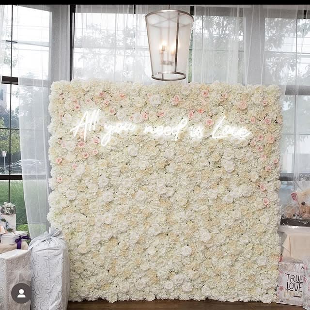 White rose flower wall with pink accents at a bridal shower